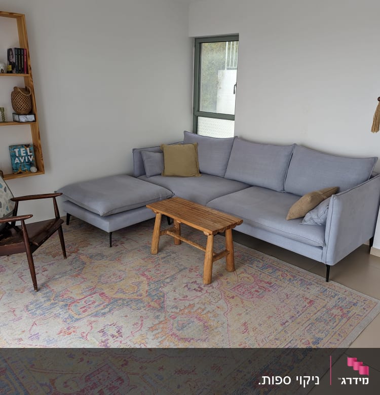 ספה אפורה עם כריות על שטיח צבעוני